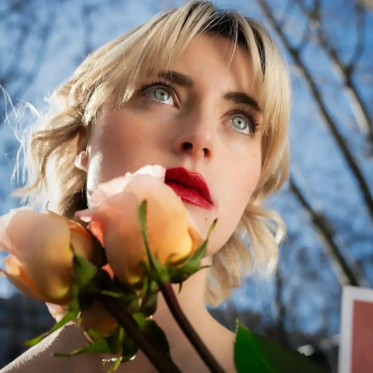 Buquê de rosas cor de pêssego em caixa de luxo - modelo a olhar ao céu com as rosas na mão| QRoses 