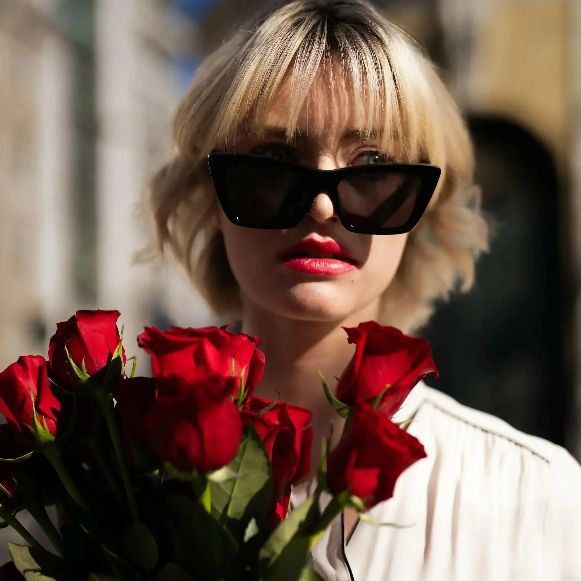 Buquê de Rosas Vermelhas e Chocolates Arcádia - modelo com os óculos pretos e as rosas vermelhas  | QRoses 